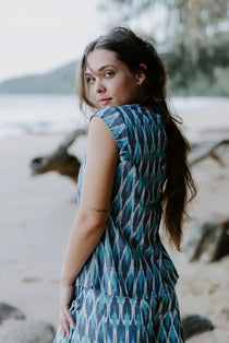 Handmade Firozi Ikat top in shades of blue, worn by a woman on a beach, showcasing ethical fashion crafted from lightweight cotton fabric